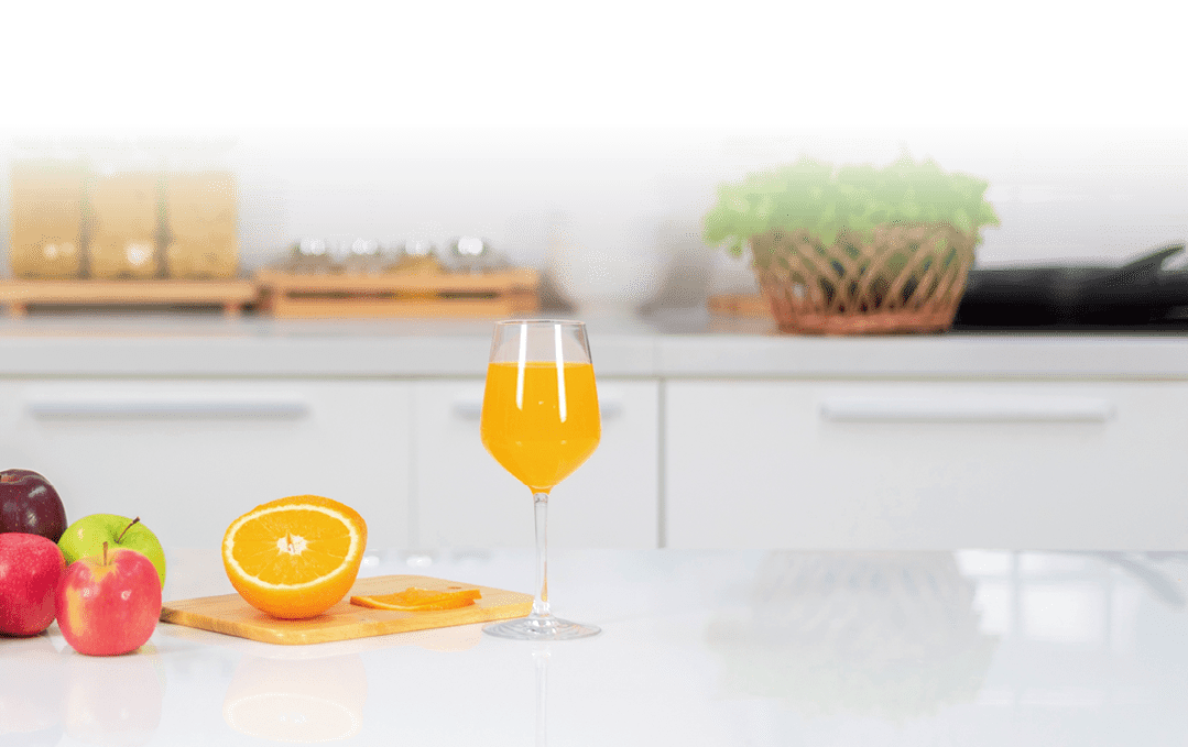 Orange juice is placed on a white table, orange juice, bright colors placed on the table and the atmosphere in the kitchen is clean white 