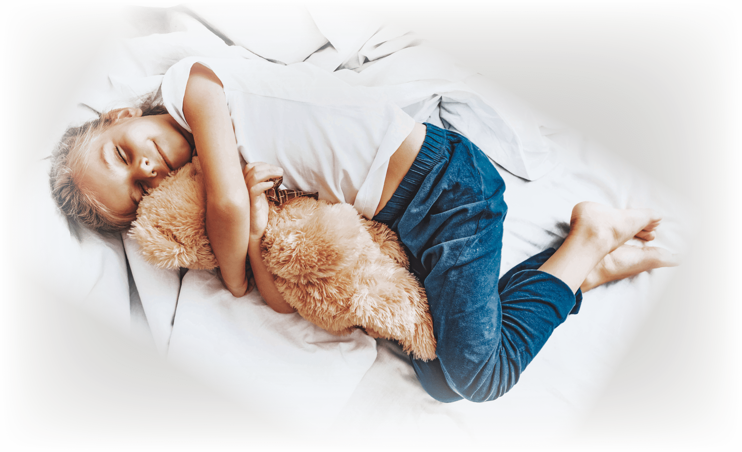 Beloved toys concept  Top view portrait of smiling little girl sleeping in bed with teddy bear toy embracing in hands