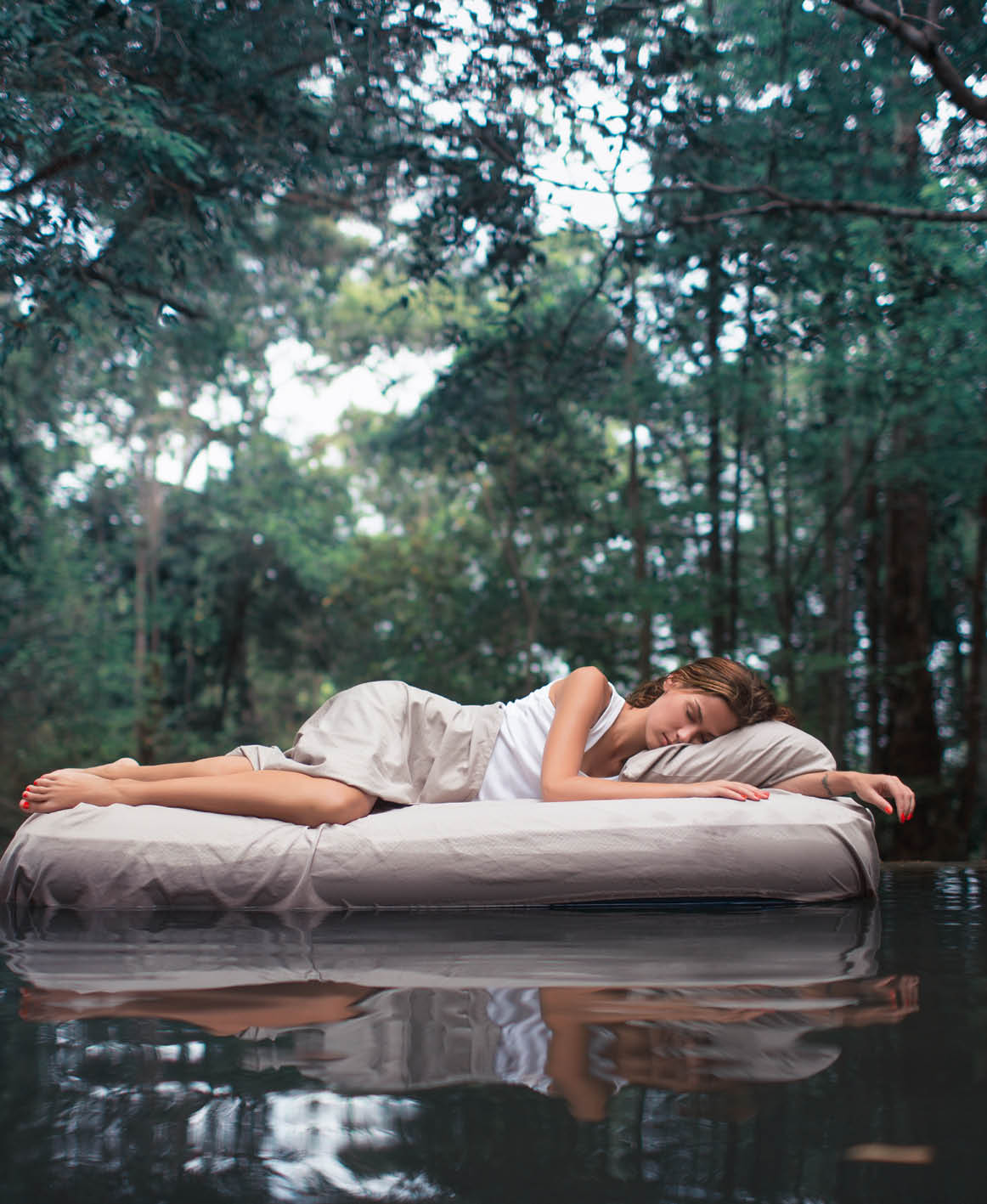 A hidden place  Sleeping woman in deep forest lies on airbed