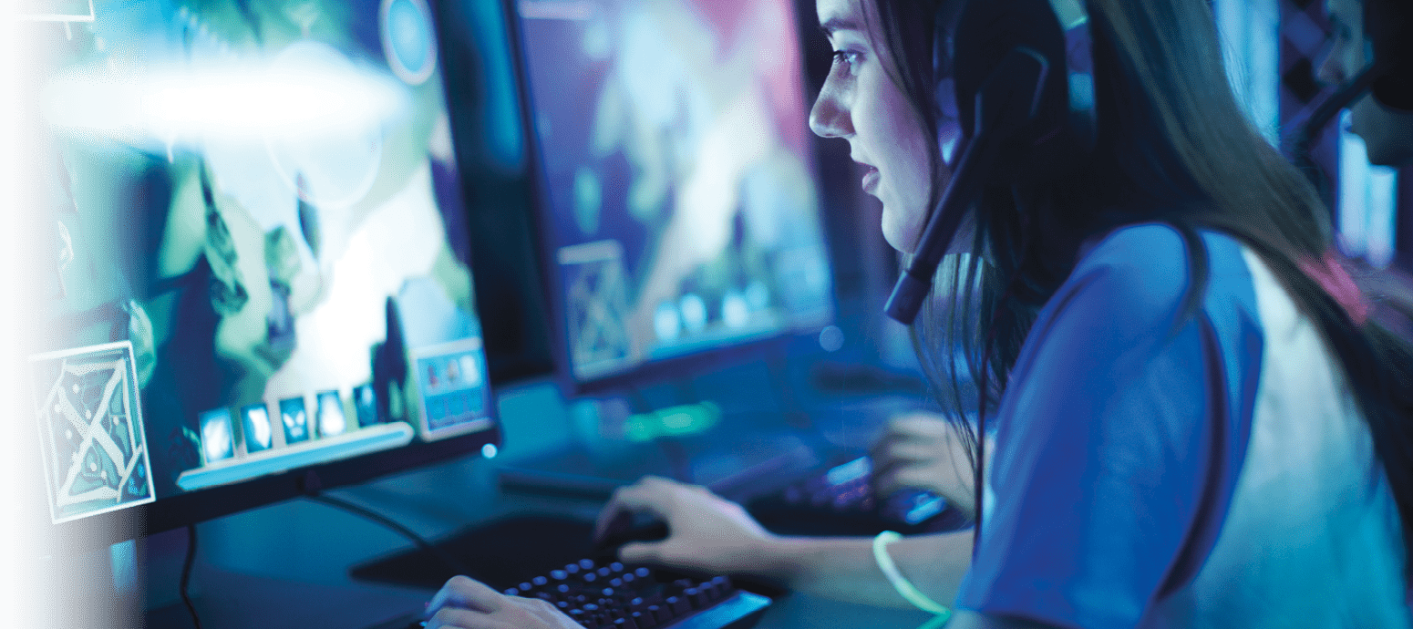 Professional Girl Gamer Plays in MMORPG/ Strategy Video Game on Her Computer. She's Participating in Online Cyber Games Tournament, Plays at Home, or in Internet Cafe. She Wears Gaming Headset.