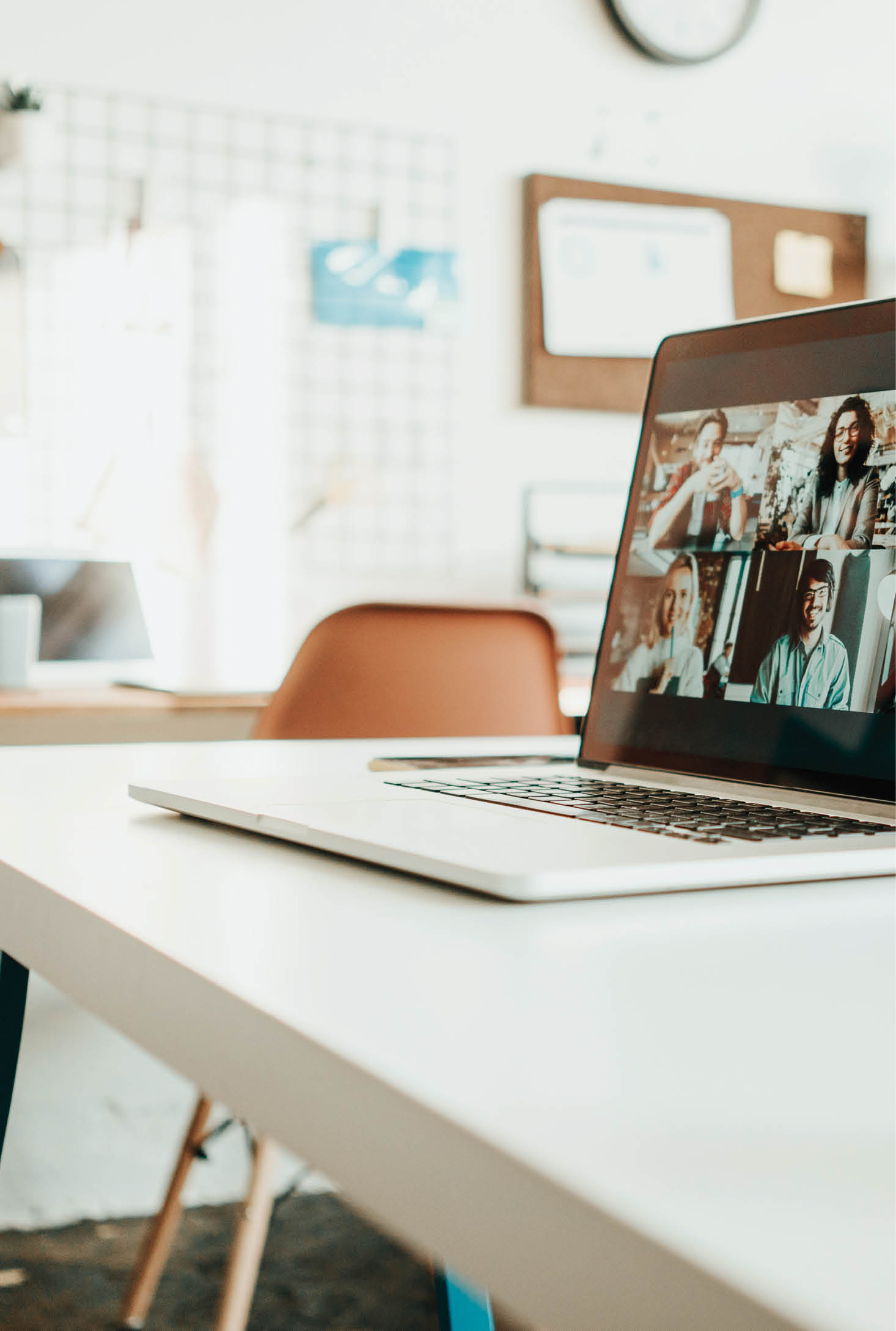 Laptop with video call conference standing on the desk in the middle of work space
