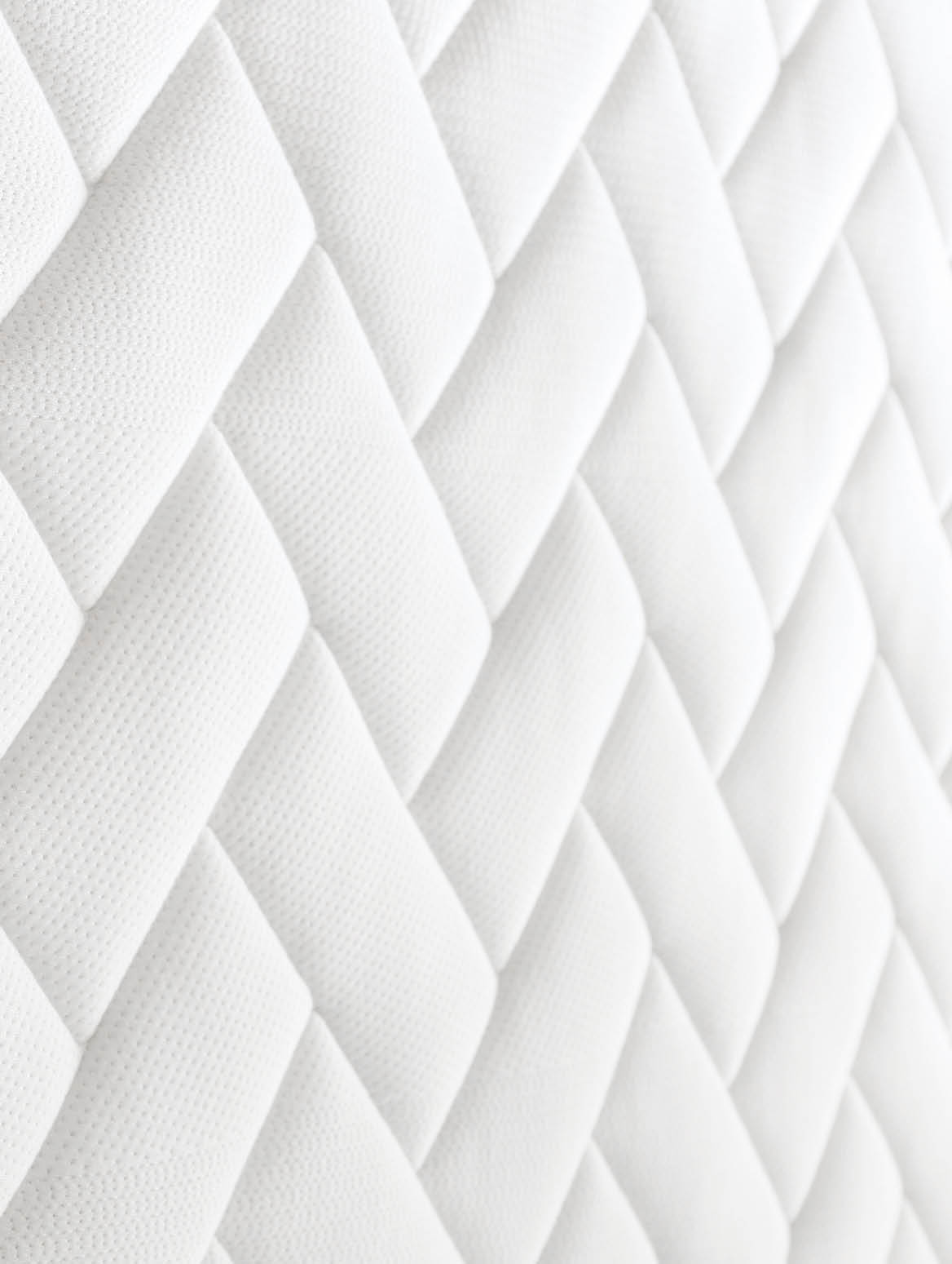Close up shot of white orthopedic mattress top side surface pattern with a lot of copy space for text  Hypoallergenic foam matress for proper spinal alingment and pressure point relief  Background 