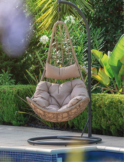 Luxurious pool in the garden of a private villa, hanging chair with pillows for leisure tourists, in summer. Portugal, Algarve