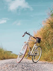 Vintage bicycle on country road and field with blue sky and white cloud abstract background. 