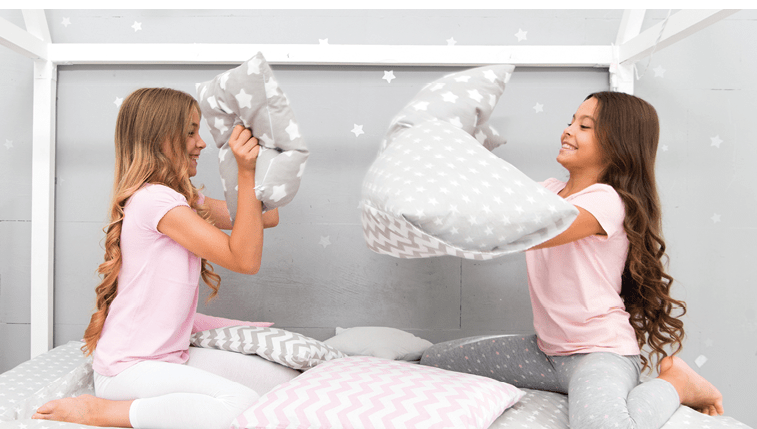 Soulmates girls having fun sleepover party. Pillow fight pajama party. Sleepover time for fun. Best girls sleepover party ideas. Girls happy best friends in pajamas with pillows sleepover party.
