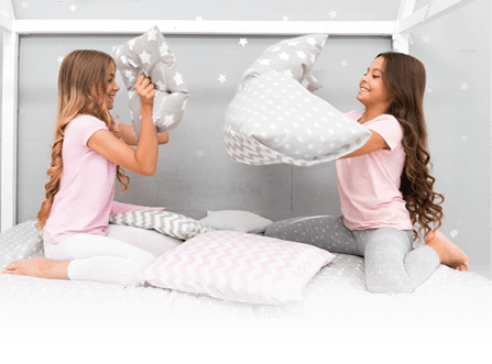 Soulmates girls having fun sleepover party. Pillow fight pajama party. Sleepover time for fun. Best girls sleepover party ideas. Girls happy best friends in pajamas with pillows sleepover party.
