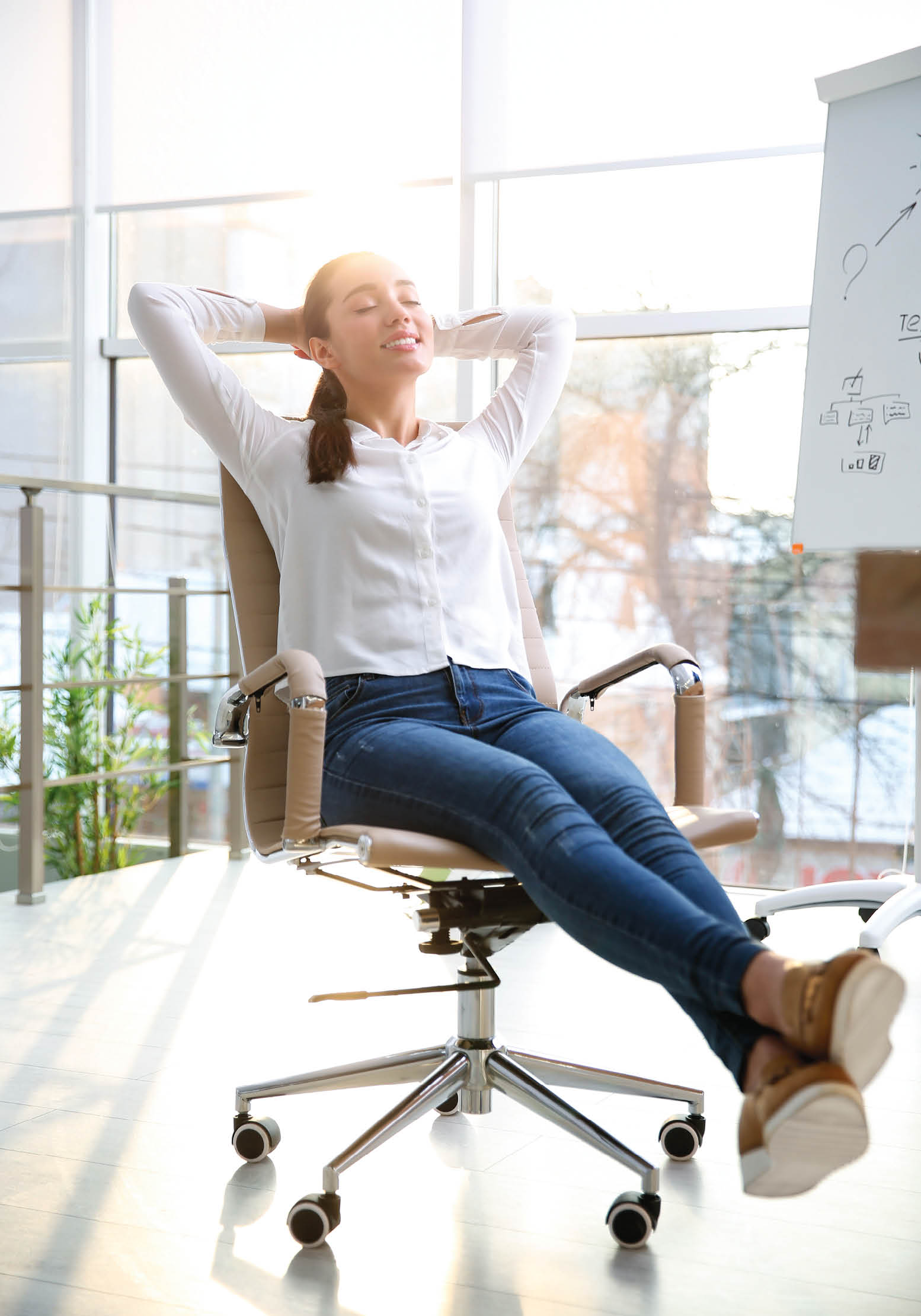 Young woman relaxing in office chair at workplace