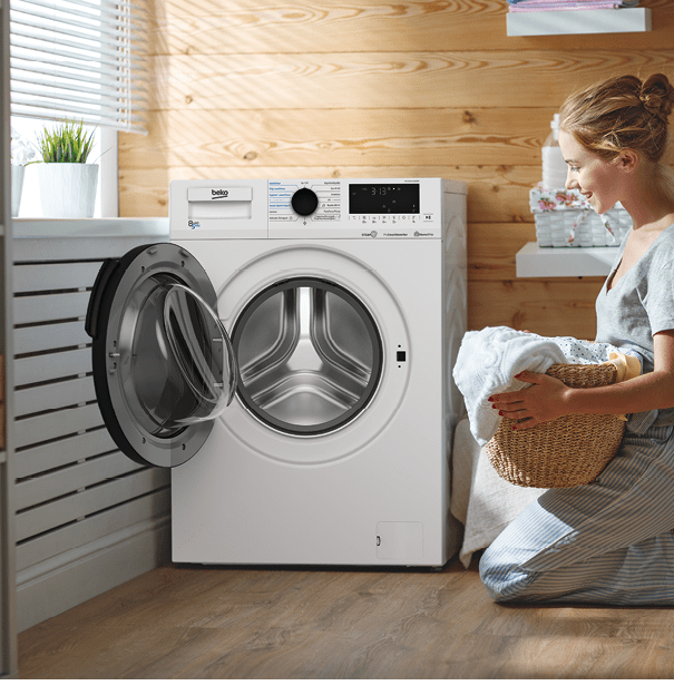 a Happy housewife woman in laundry room with washing machine  