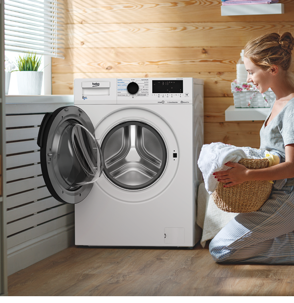 a Happy housewife woman in laundry room with washing machine  