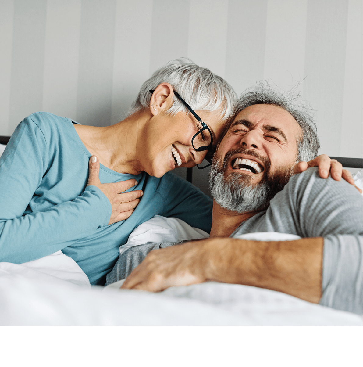 Portrait of a happy senior couple embracing each other on bed, elderly couple at home