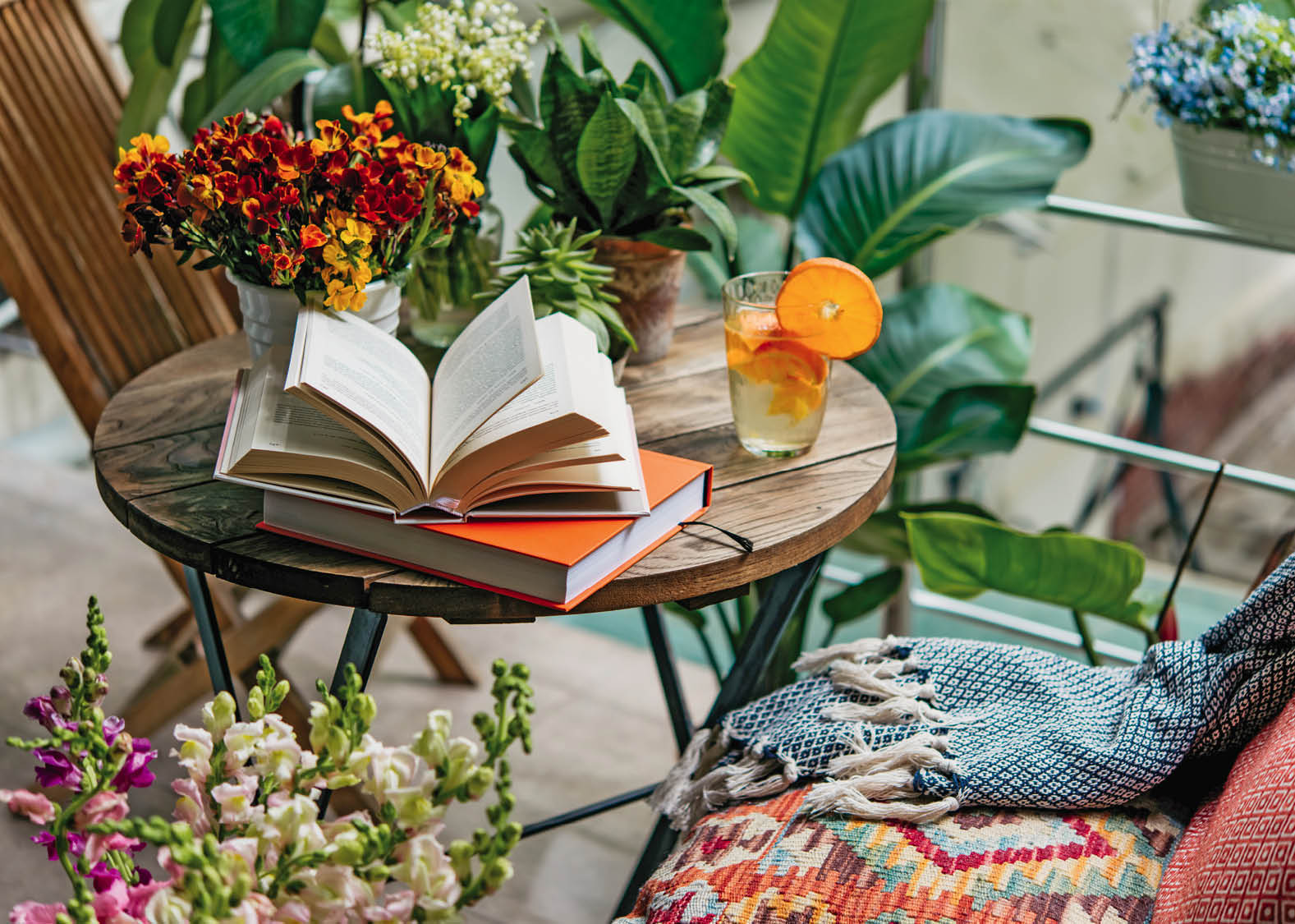 Reading books in summer at a beautiful terrace or cozy balcony full of green plants.