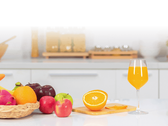 Orange juice is placed on a white table, orange juice, bright colors placed on the table and the atmosphere in the kitchen is clean white.