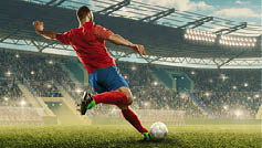 Professional soccer player with a ball in action. Soccer stadium with tribunes and fans cheering. Sports event