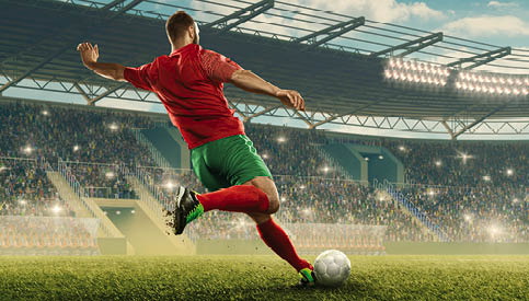 Professional soccer player with a ball in action. Soccer stadium with tribunes and fans cheering. Sports event