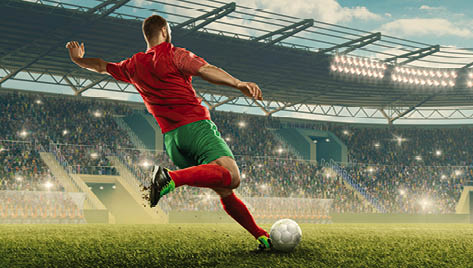 Professional soccer player with a ball in action. Soccer stadium with tribunes and fans cheering. Sports event