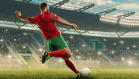 Professional soccer player with a ball in action. Soccer stadium with tribunes and fans cheering. Sports event