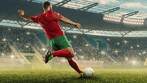 Professional soccer player with a ball in action. Soccer stadium with tribunes and fans cheering. Sports event