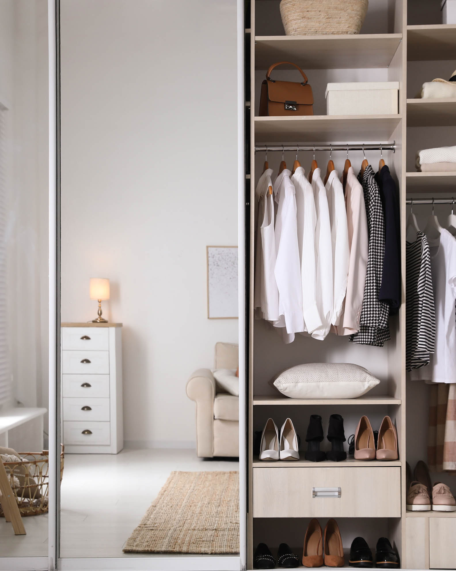 Wardrobe closet with different stylish clothes, shoes and home stuff in room