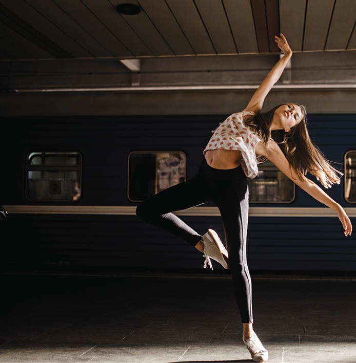 Caucasian woman dancing near train