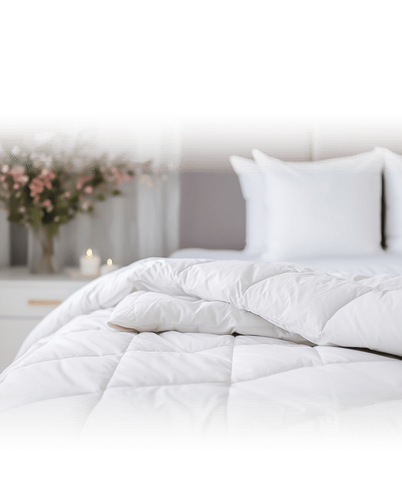 white soft duvet lying against background headboard with pillows,bedside table with flowers,candles,close-up,concept preparing for winter season,household chores,comfort in house,hotel,home textiles
