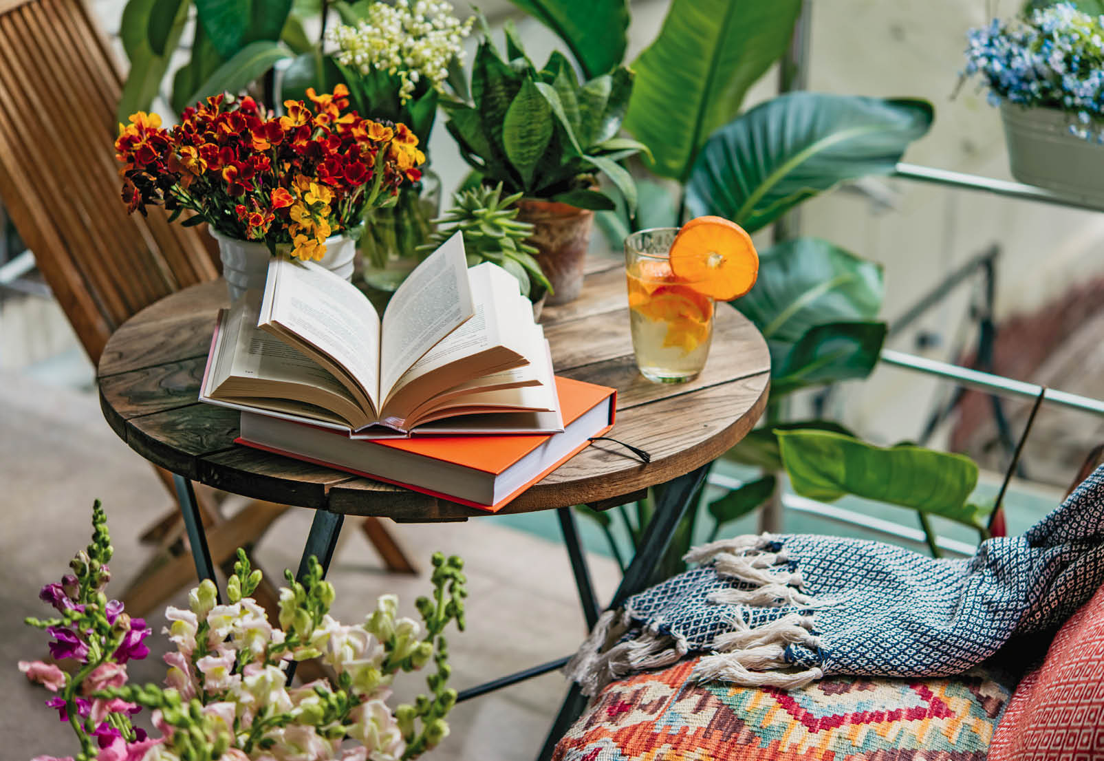 Reading books in summer at a beautiful terrace or cozy balcony full of green plants.