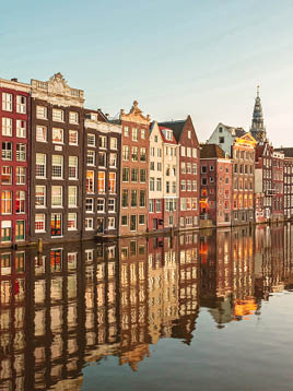 Row of ancient canal houses in the Dutch capital city Amsterdam with a canal in front