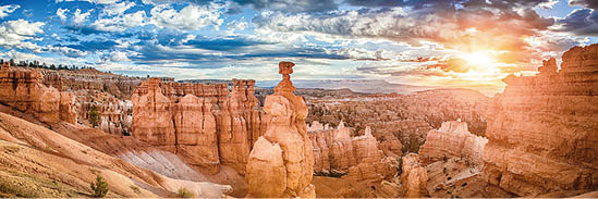 Panoramic view of amazing hoodoos sandstone formations in scenic Bryce Canyon National Park in beautiful golden morning light at sunrise with dramatic sky and blue sky, Utah, USA