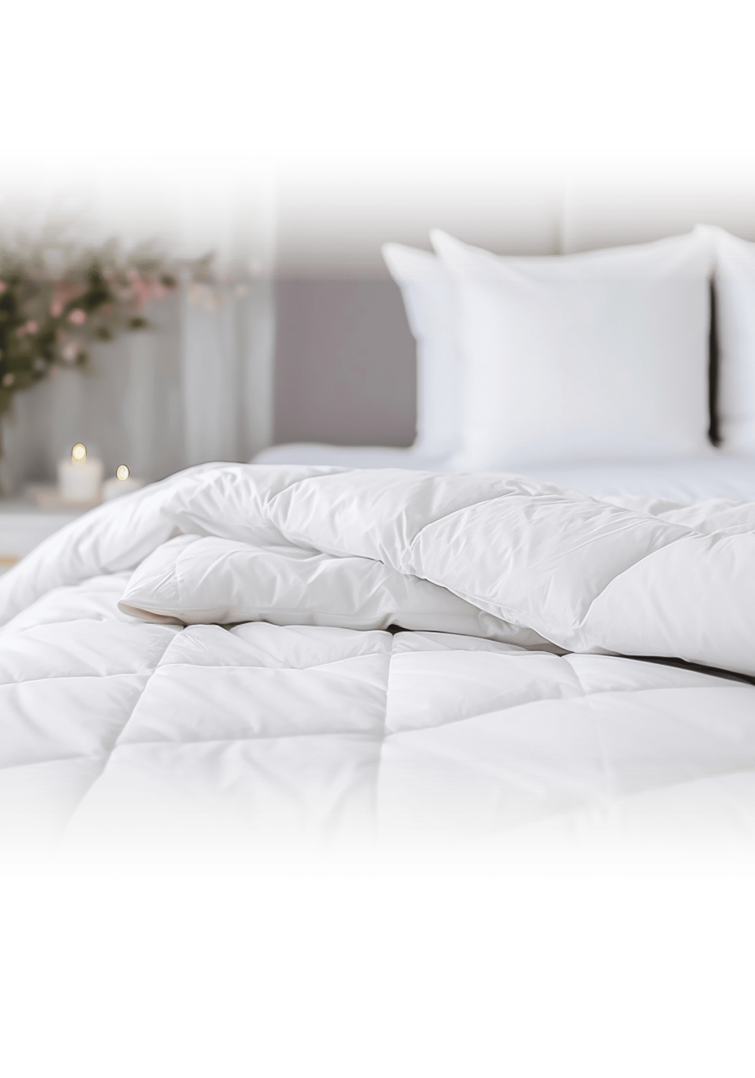 white soft duvet lying against background headboard with pillows,bedside table with flowers,candles,close-up,concept preparing for winter season,household chores,comfort in house,hotel,home textiles