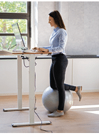 Woman Using Adjustable Height Standing Desk In Office For Good Posture