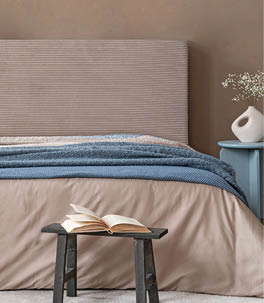 Minimalist bedroom decor with abstract artwork, a soft-toned bed, and sculptural bedside accessories in organic shapes.