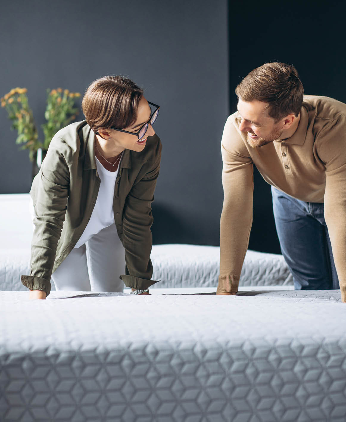 Couple buying new bed with orthipedic mattress in furniture store