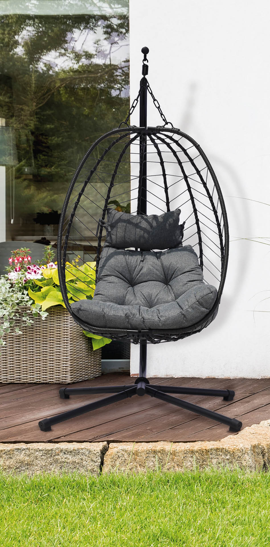 Garden with green grass and four bushes next to a house