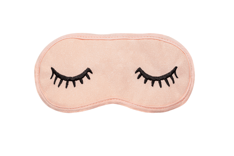 Pastel pink sleep mask with closed eyes embroidered on it with eyelashes on white background. Top view, flat lay. Concept of vivid dreams. Accessories for girls and young women