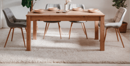 A wooden dining table with four chairs around it. AI generated content