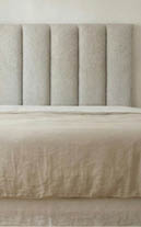 A bed with a white comforter and pillows. AI generated content