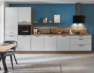 A large, clean kitchen with white cabinets and blue walls. A stove top oven is visible, along with a microwave. A dining table is surrounded by chairs, and a potted plant is placed nearby. A vase is also present in the room. AI generated content