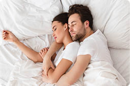 Top View Of Loving Married Couple Sleeping Together Embracing Resting In Bed In Bedroom Indoors. Happy Marriage And Relationship. Husband And Wife Hugging While Napping At Home. Vertical