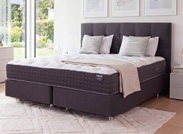 A bed with a white mattress and a red logo on the headboard. AI generated content