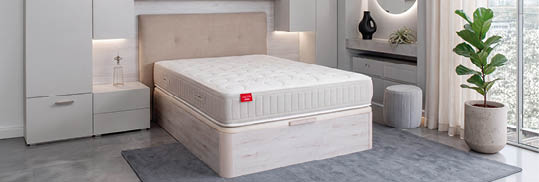 A bed with a white mattress and a red logo on the headboard. AI generated content