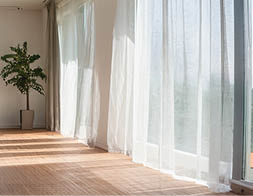 A large living room with a couch, a potted plant, and a large window. AI generated content