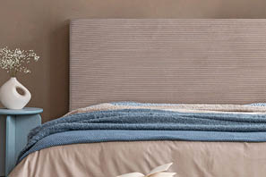 Minimalist bedroom decor with abstract artwork, a soft-toned bed, and sculptural bedside accessories in organic shapes.