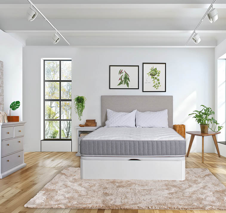 A bed with a white mattress and a grey cover. AI generated content