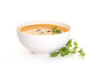 A white bowl filled with a creamy soup containing a sprig of parsley. AI generated content