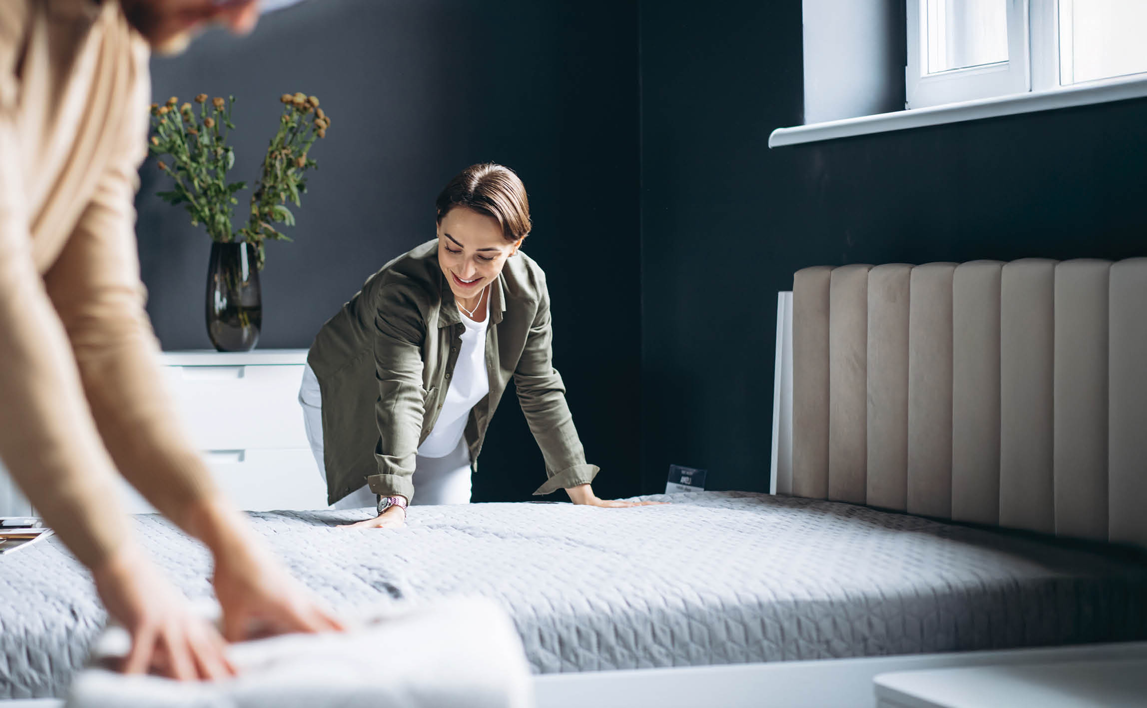 Couple buying new bed with orthipedic mattress in furniture store