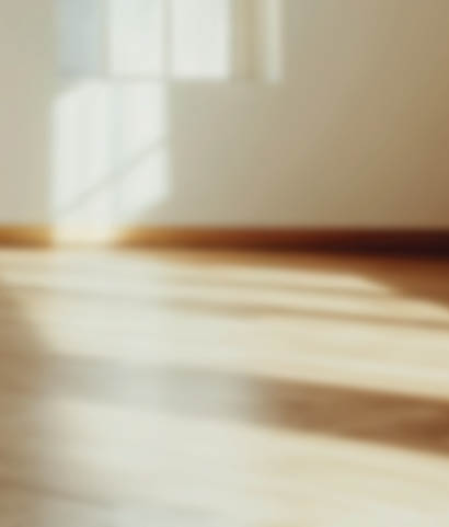 Empty modern room with sunlight streaming through a large window, creating warm shadows on white walls and polished wood floors.