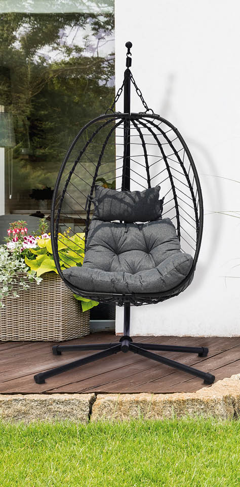 Garden with green grass and four bushes next to a house