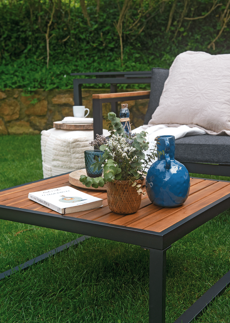 A black patio table with a blue vase and a white vase on it. AI generated content