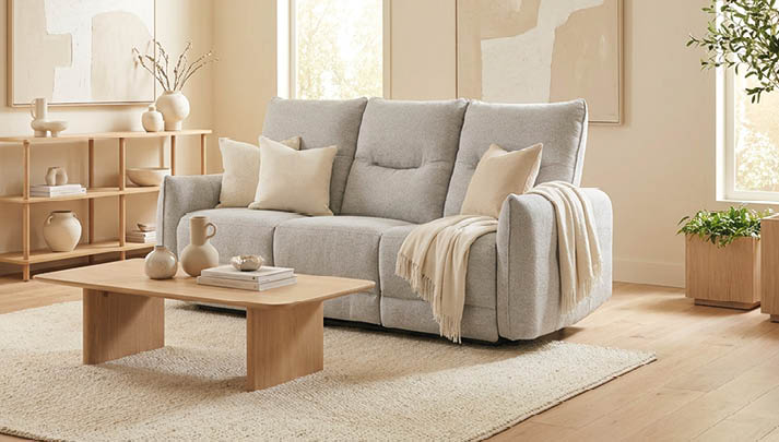 A large couch with a white blanket on it is in a living room with a window. AI generated content