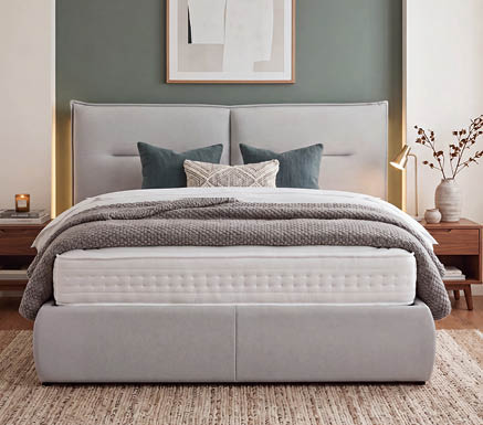 A bed with a white pillow and a tan headboard. AI generated content