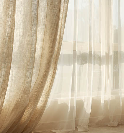Sunlight streams through sheer beige curtains